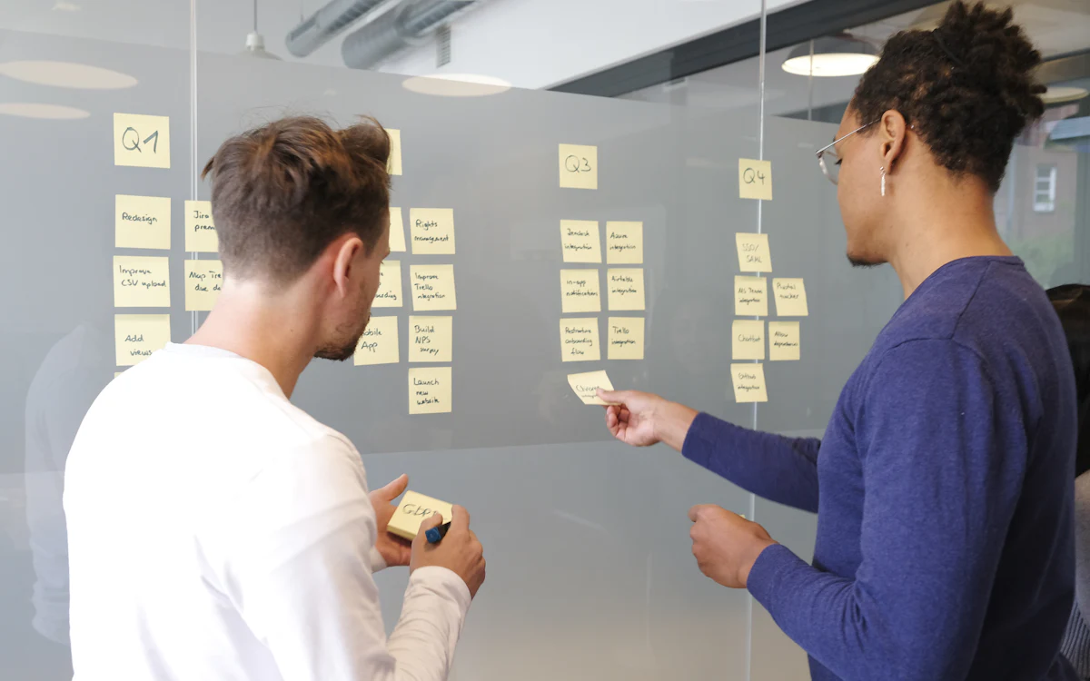 Dues persones planificant un projecte amb notes adhesives
