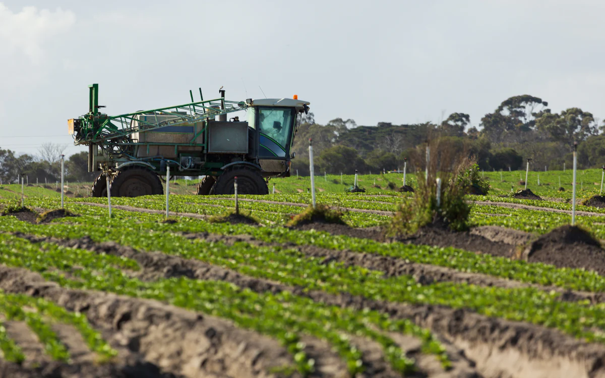 Tractor aplicando tratamiento fitosanitario en un campo